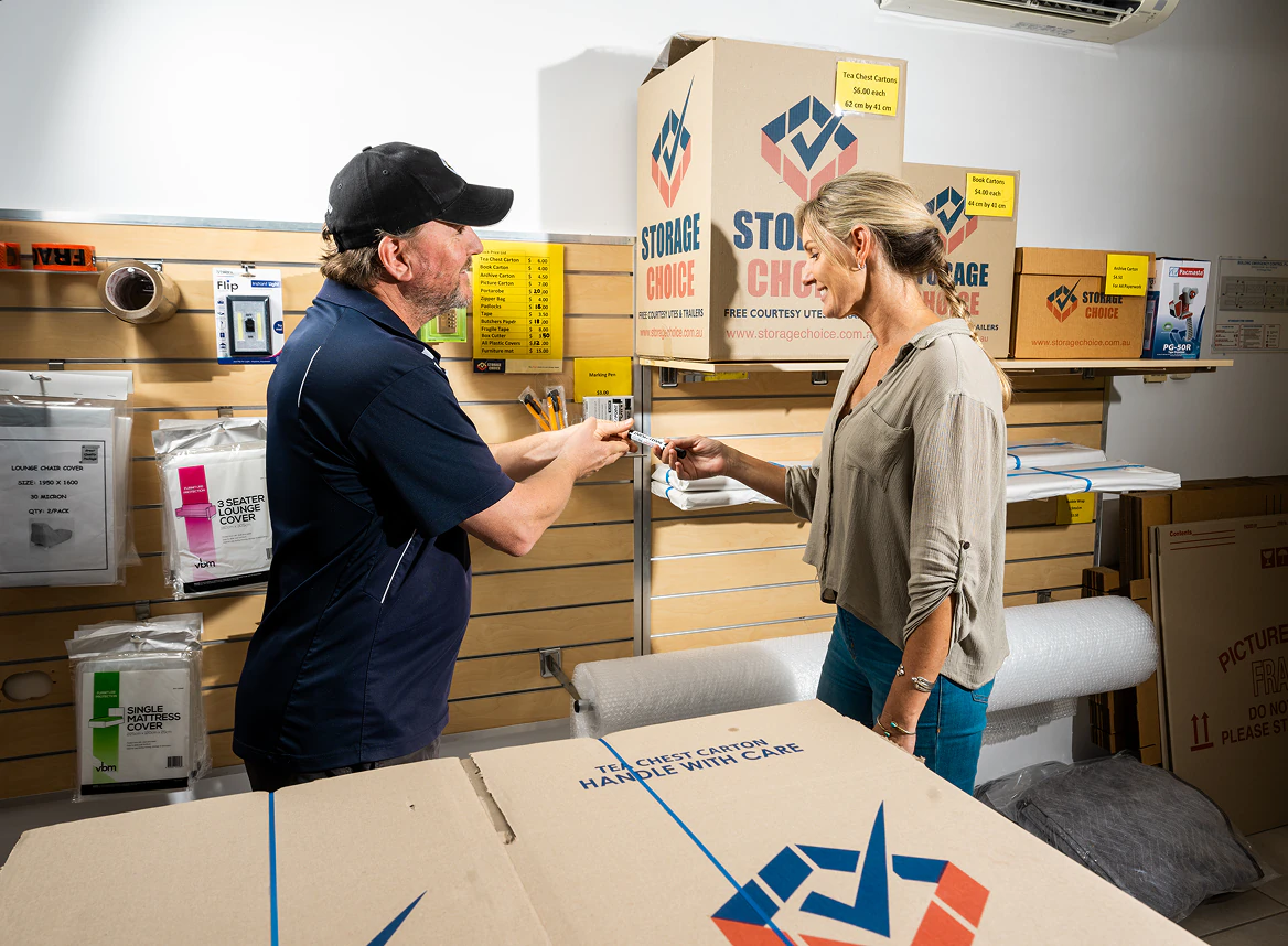 Storage Choice manager showing a customer packing supplies beside stacked moving boxes