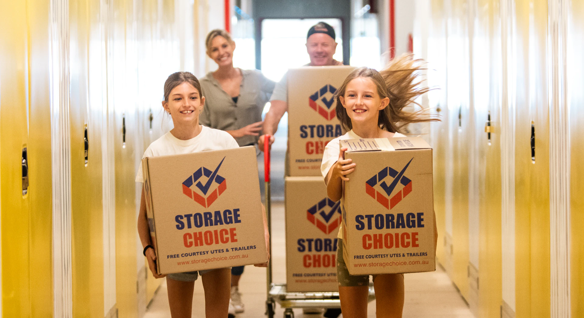 Family holding Storage Choice moving boxes inside a self-storage unit