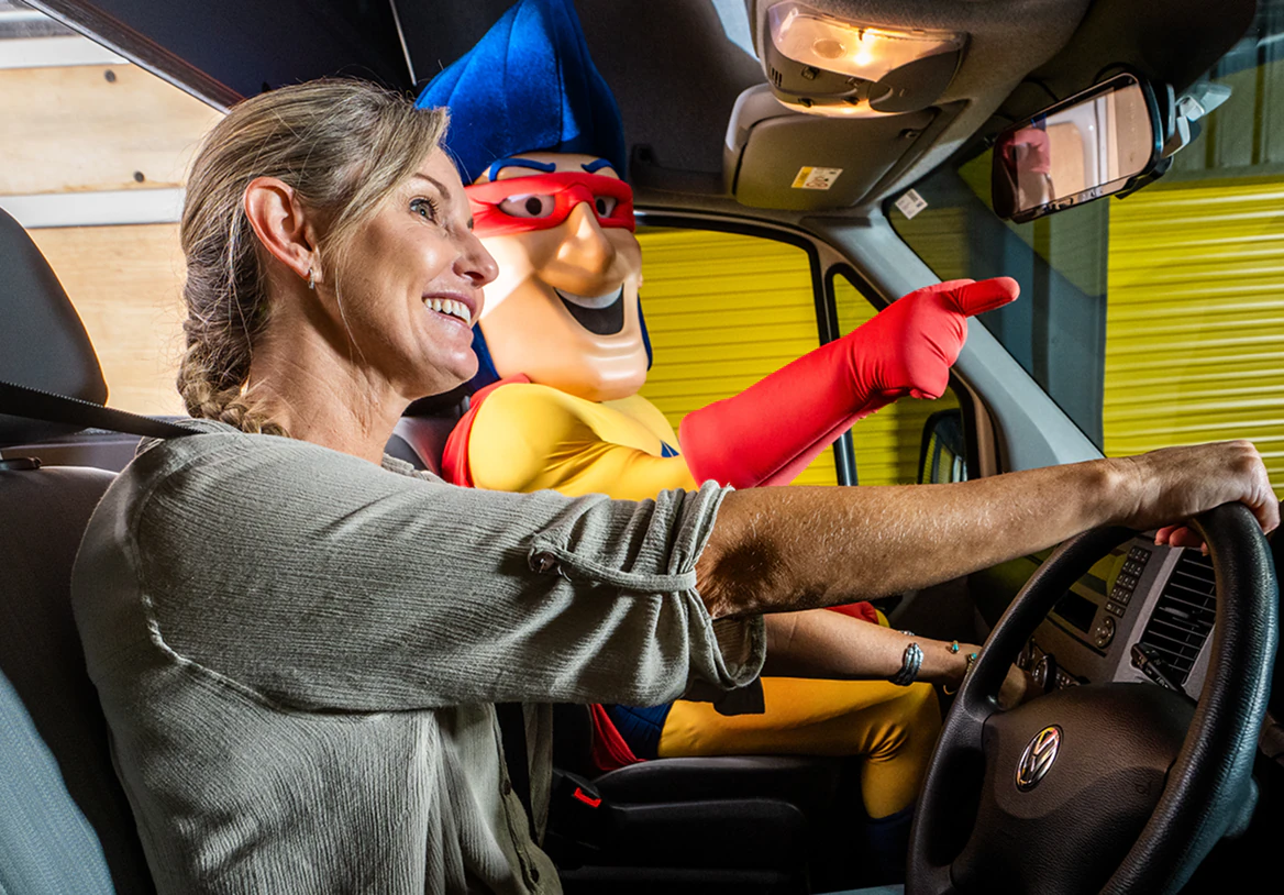Customer driving a car with the Storage Choice StoreMan mascot in the passenger seat